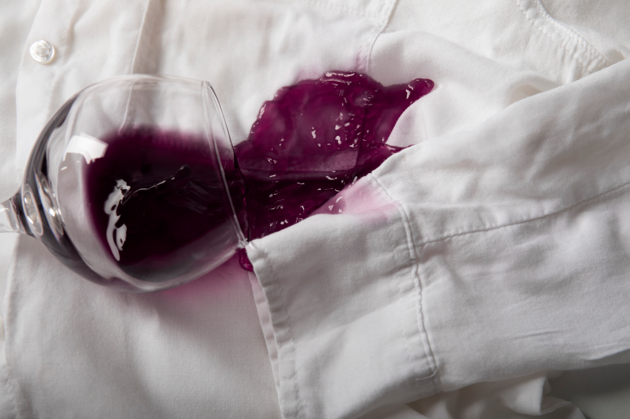 A glass of red wine was spilled on a white shirt.