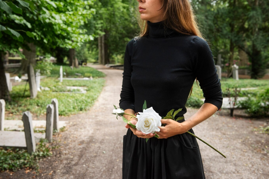 A woman holding flowers at a funeral