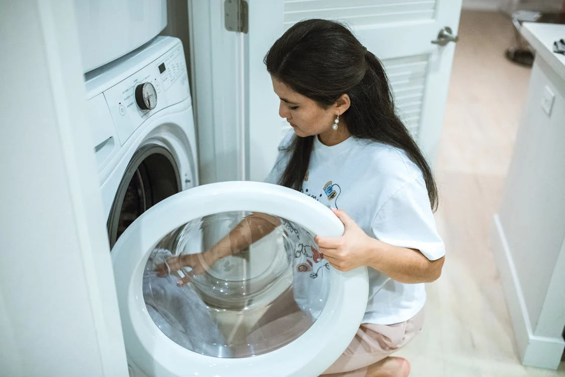 woman washing clothes with dye stains, woman doing laundry